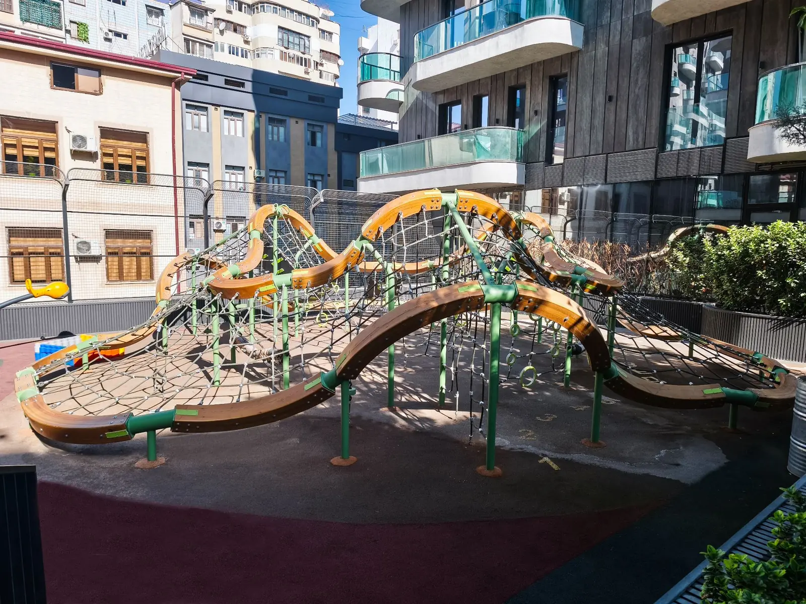Wave-shaped timber and rope climbing structure in an urban courtyard, Uzbekistan