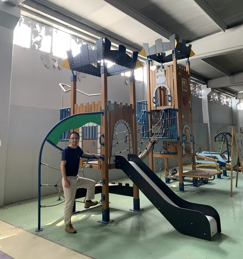 Ernes at the Cemer showroom beside a wooden castle play structure
